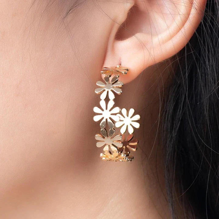 Pair of golden geometric C-shaped flower drop earrings with a vintage-inspired design