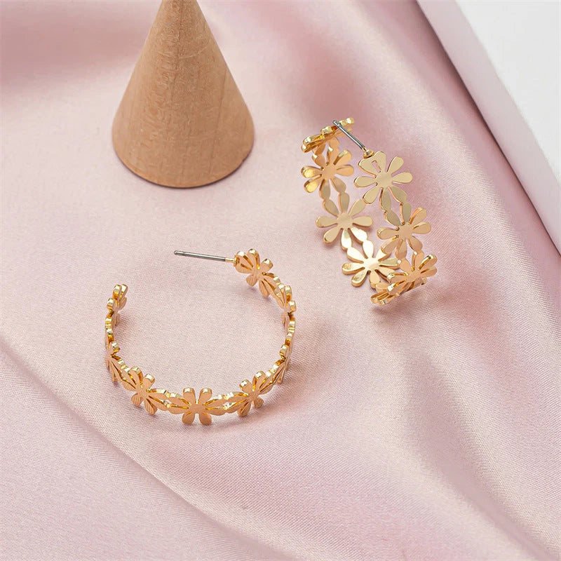 Pair of golden geometric C-shaped flower drop earrings with a vintage-inspired design