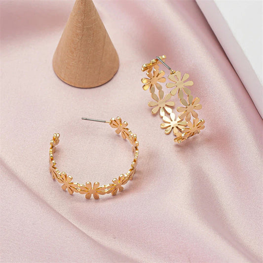 Pair of golden geometric C-shaped flower drop earrings with a vintage-inspired design