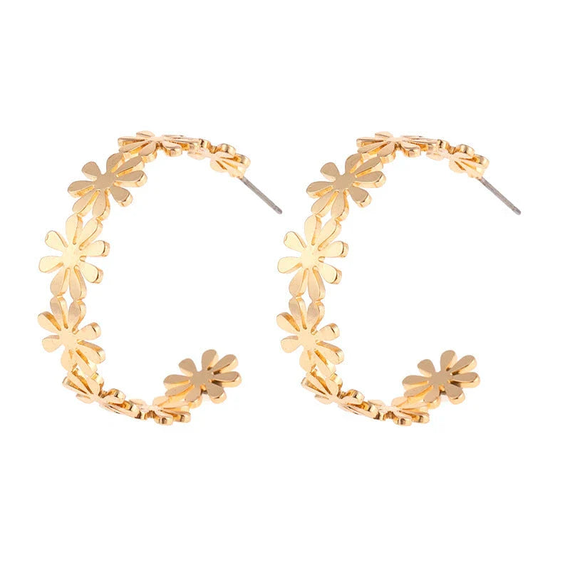 Pair of golden geometric C-shaped flower drop earrings with a vintage-inspired design