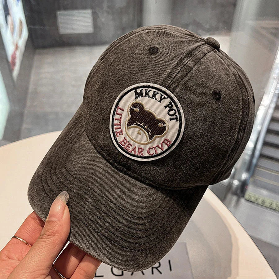 Two pink baseball caps featuring a cartoon love design, perfect for casual and festival wear