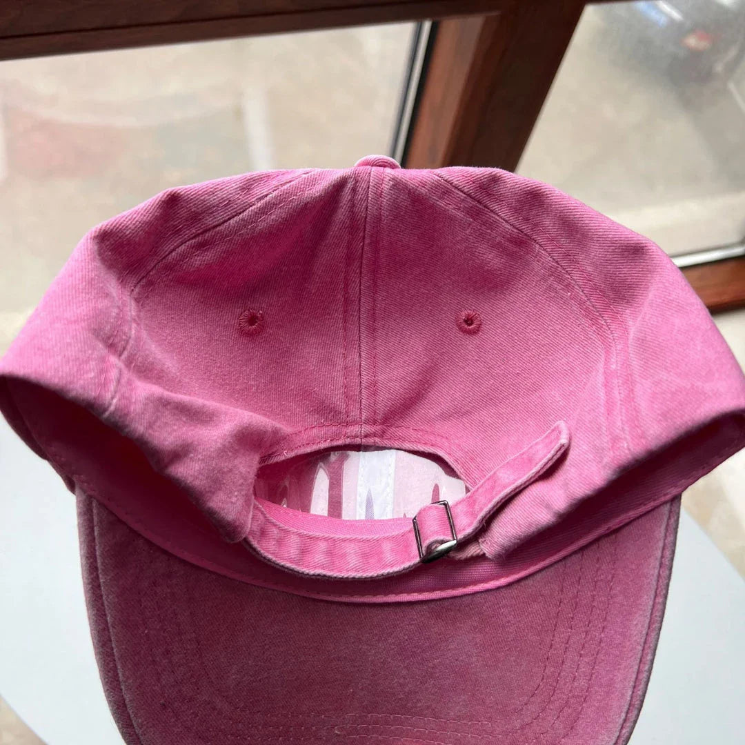 Two pink baseball caps featuring a cartoon love design, perfect for casual and festival wear