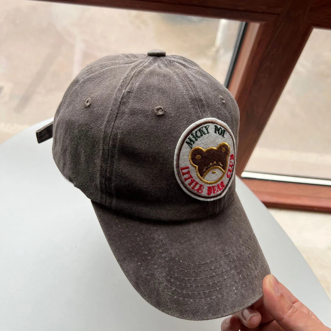 Two pink baseball caps featuring a cartoon love design, perfect for casual and festival wear