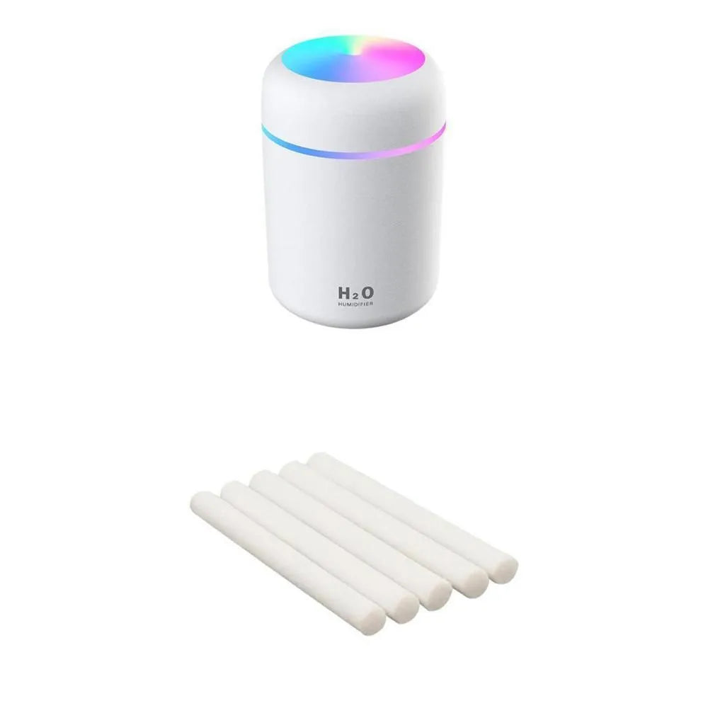 Pink USB desktop humidifier with LED lights and water tank on wooden desk