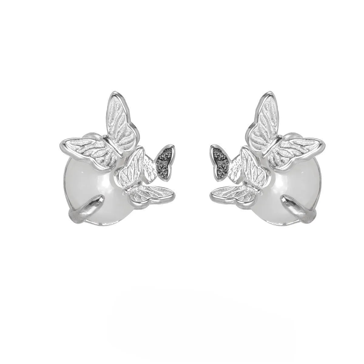 Close-up of a pair of 925 silver butterfly ear studs with gold plating, showing detailed animal zodiac modelling.