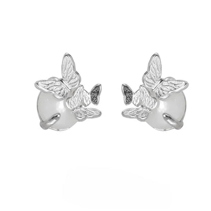 Close-up of a pair of 925 silver butterfly ear studs with gold plating, showing detailed animal zodiac modelling.