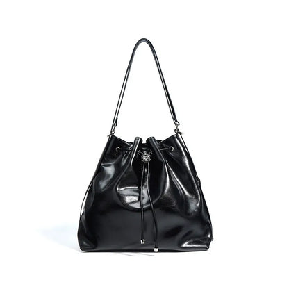 Brown genuine leather retro-style bucket bag with a single shoulder strap showing internal zipped compartments.