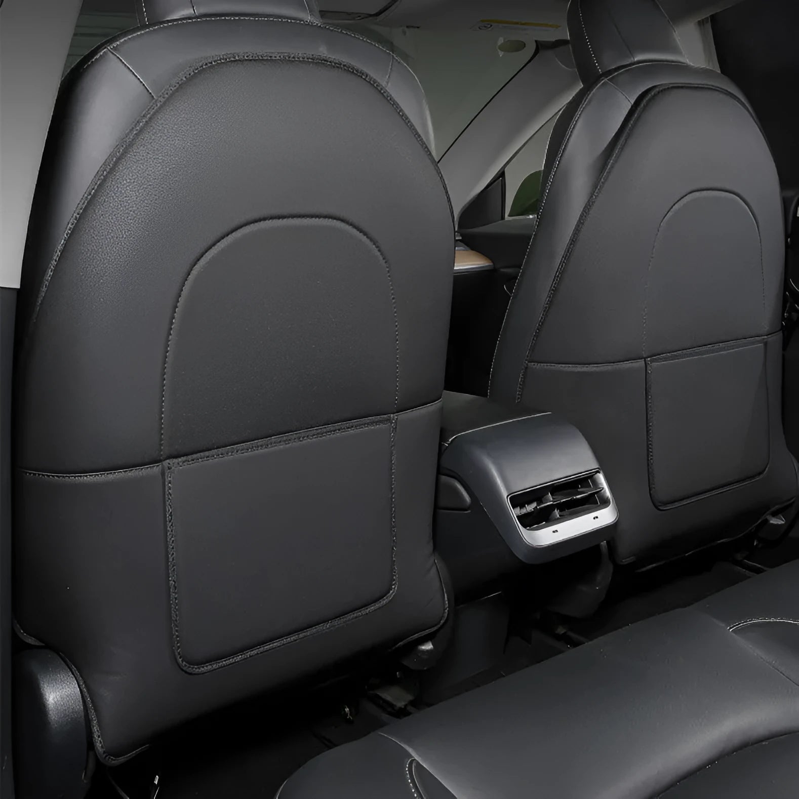 A pair of black leather rear anti kick pads for car seats, shown with dimensions.