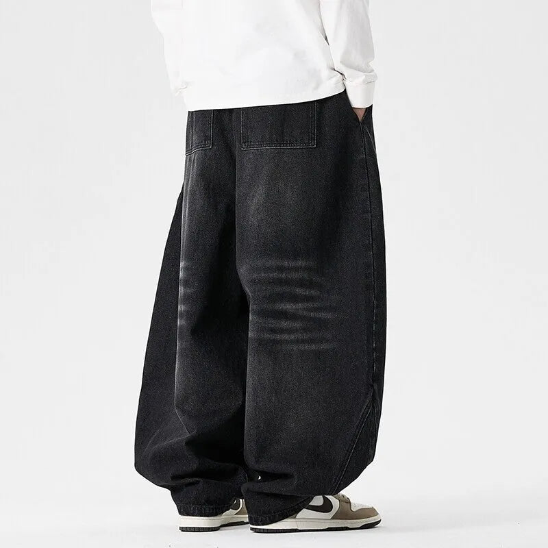 Men's plus-size light blue wide-leg baggy jeans on a neutral background.