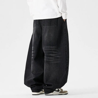 Men's plus-size light blue wide-leg baggy jeans on a neutral background.