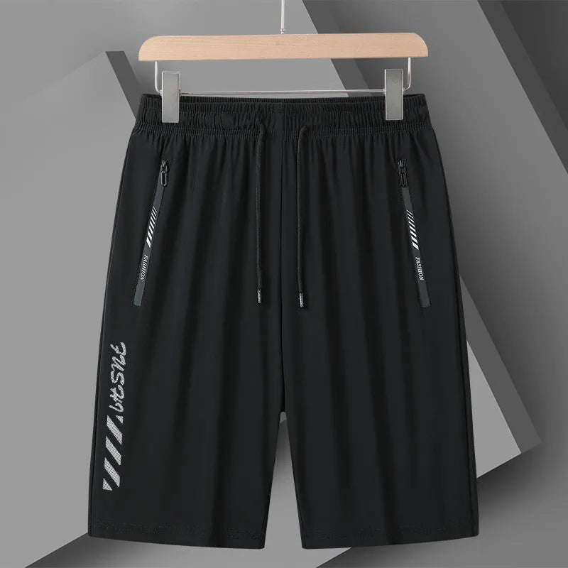 Man wearing black loose-fit quick-dry nylon sports shorts with an elastic waistband.