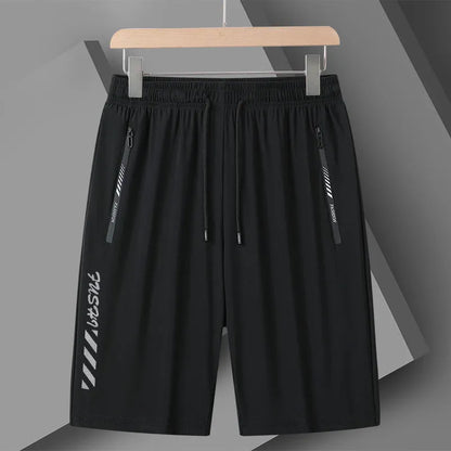 Man wearing black loose-fit quick-dry nylon sports shorts with an elastic waistband.