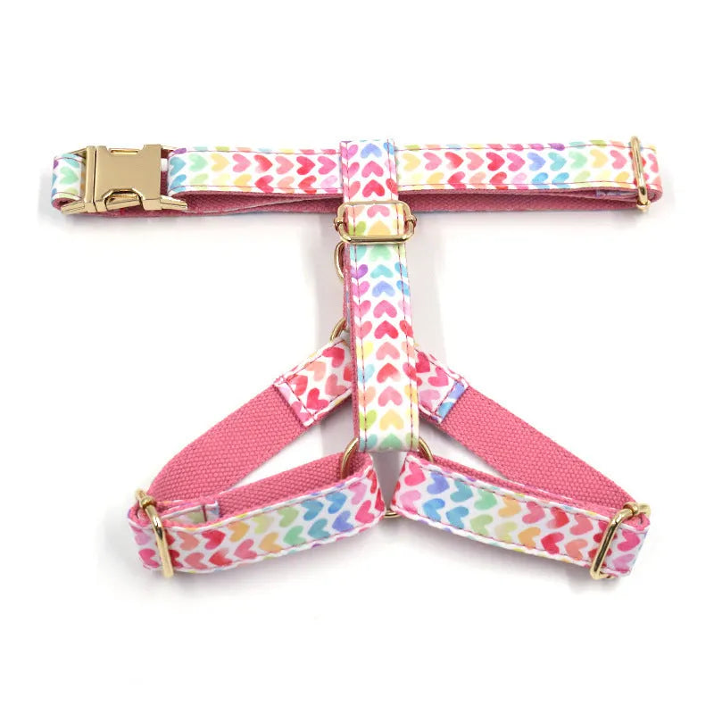 Pink dog harness with gold buckle and heart-shaped stones on a chest and back strap.