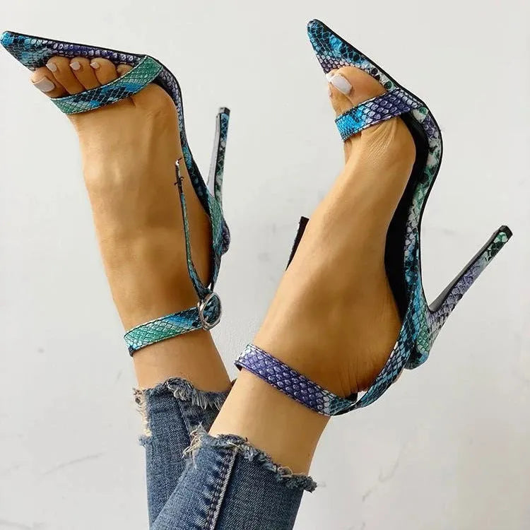 Blue women's buckle sandals with hollow-out detail and pointed toe on a white background.