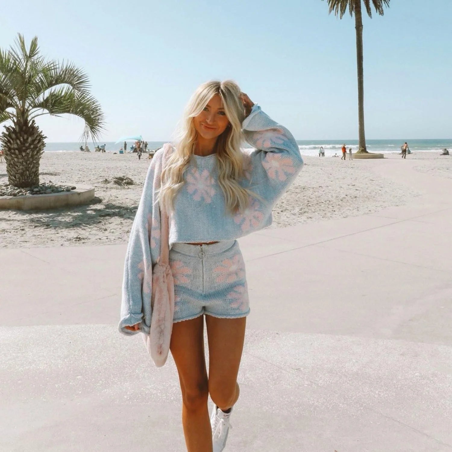 Stylish floral wool suit set with wide leg shorts and embroidered sweater, available in white, pink, brown, and blue.