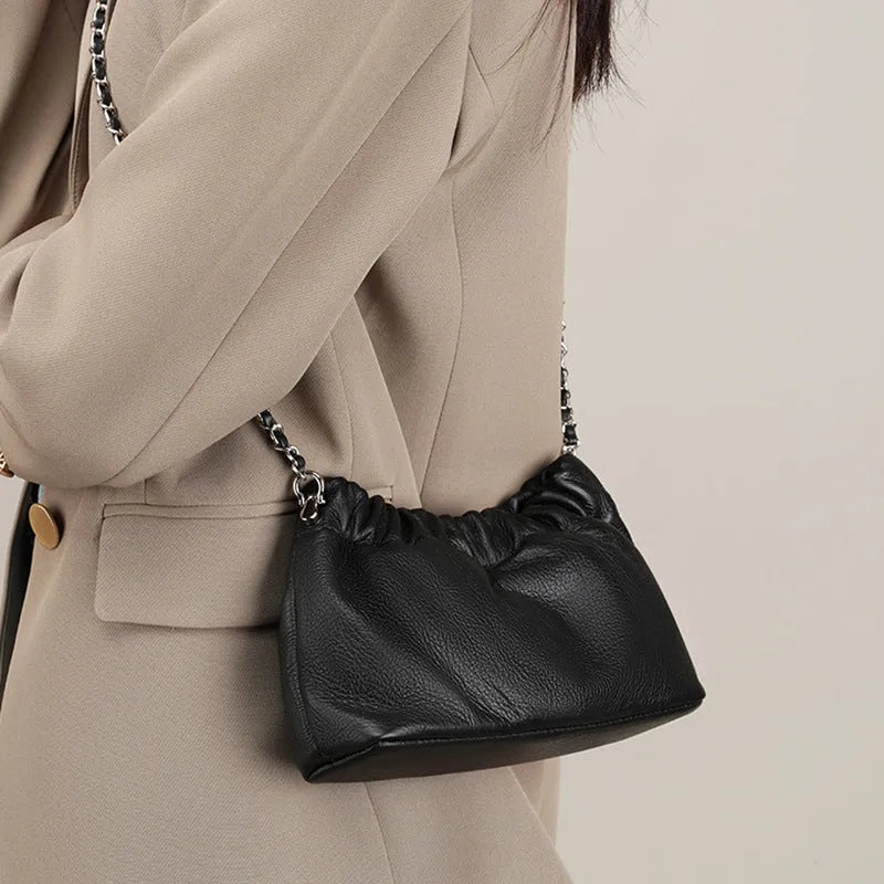 Women's dumpling-shaped genuine leather crossbody bag in three neutral colours showing slit pocket