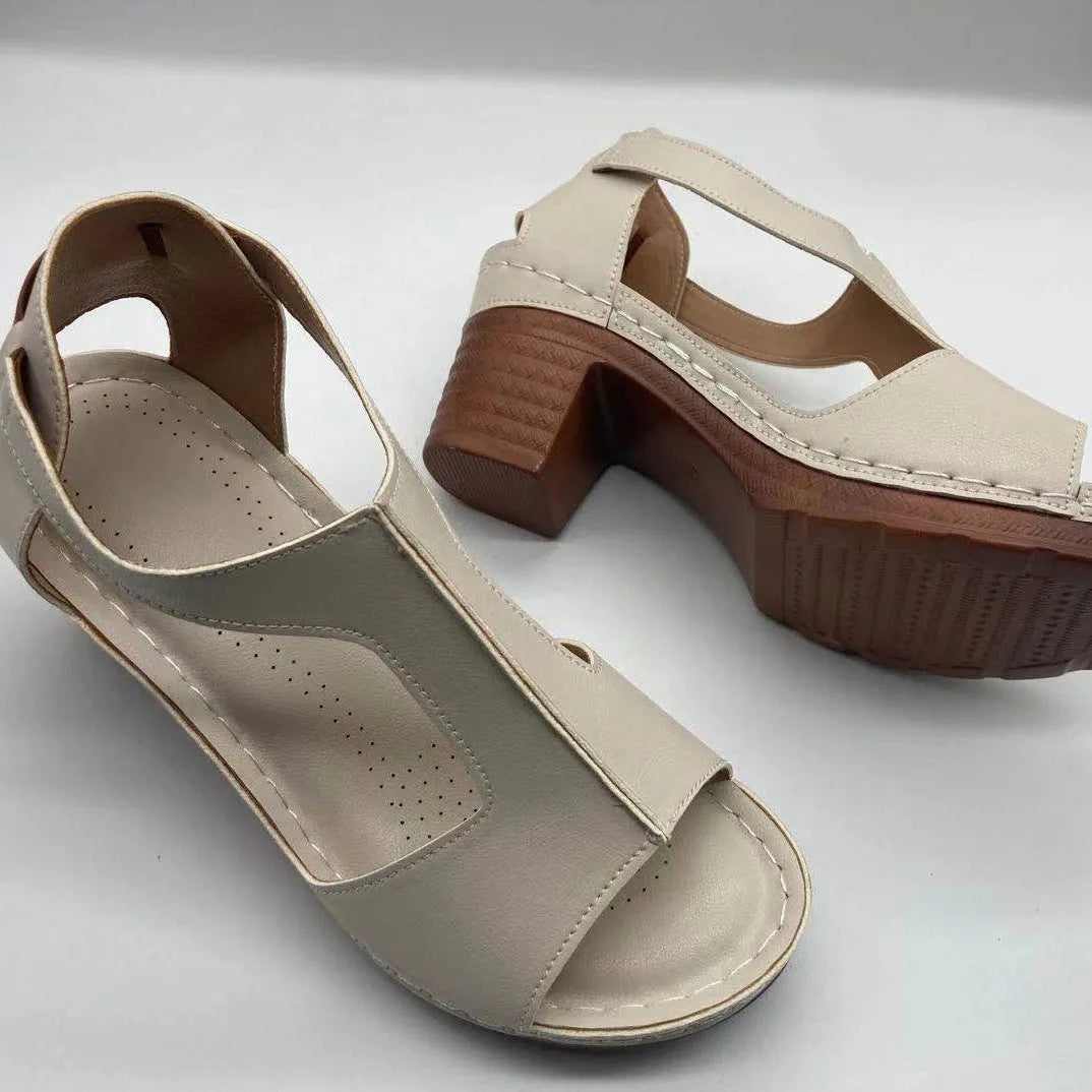 Women's beige peep toe wedge sandals with a buckle strap and low heel on a white background.