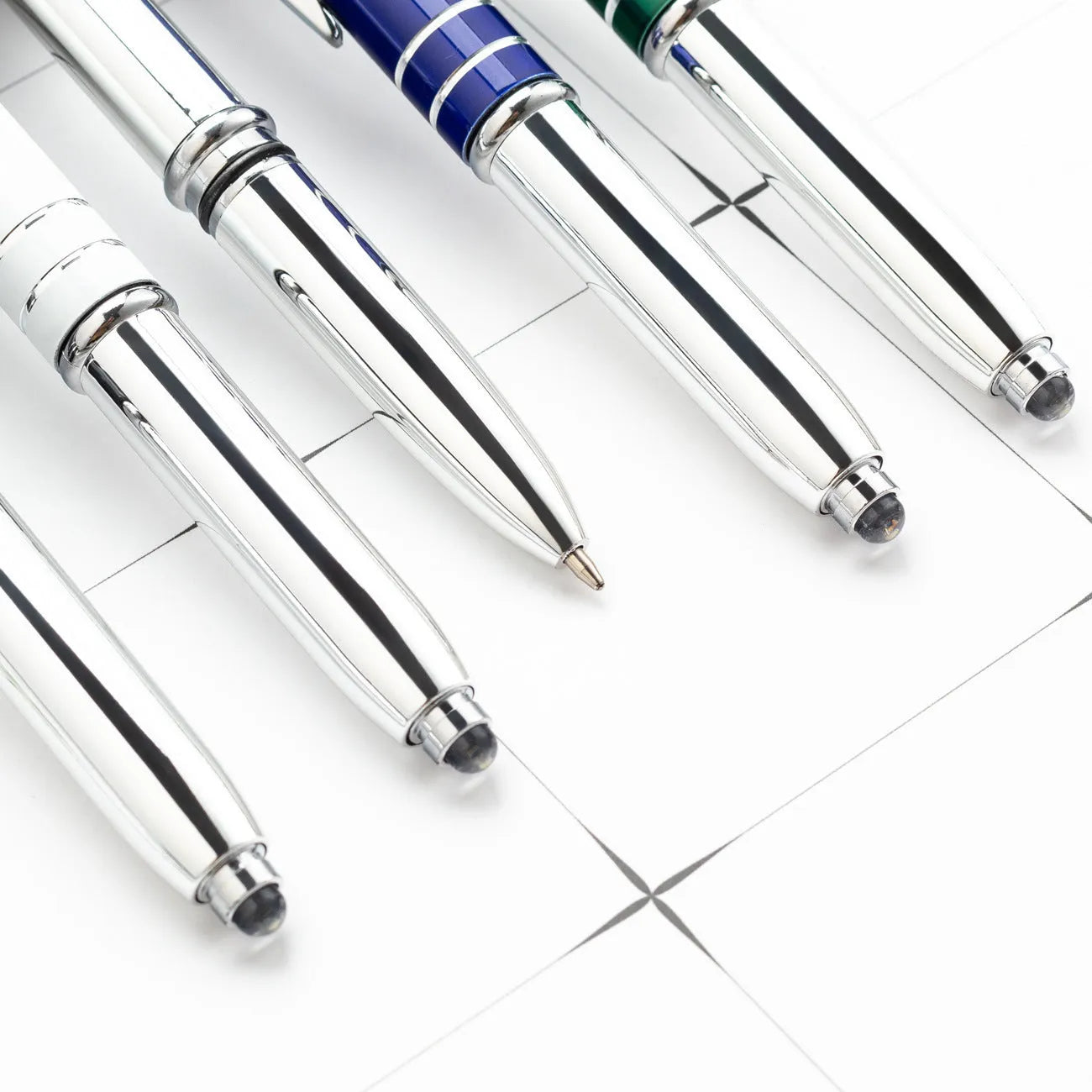 Red metal multifunctional stylus ballpoint pen with LED light on a desk.