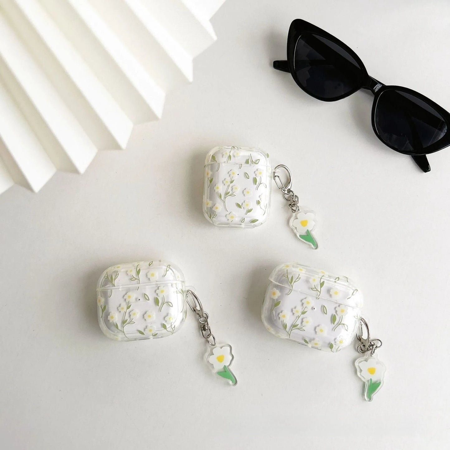 Clear white floral TPU protective cover on an Apple AirPods Pro charging case.