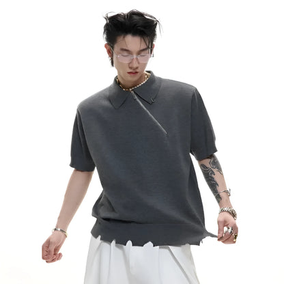 Man wearing a slim-fit black polo shirt with an oblique diagonal zipper and short sleeves.