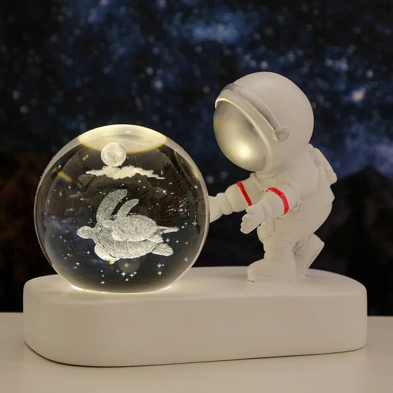 Glowing astronaut crystal ball night light with 6cm diameter and USB cable on wooden surface