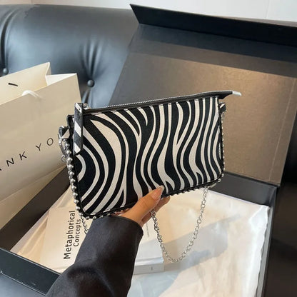 Western style women's brown crossbody bag with chain strap and horizontal square silhouette