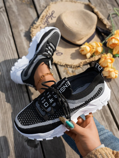 Women's Flyknit mesh lace-up sneaker in a grey colourway showing round toe and rubber sole.