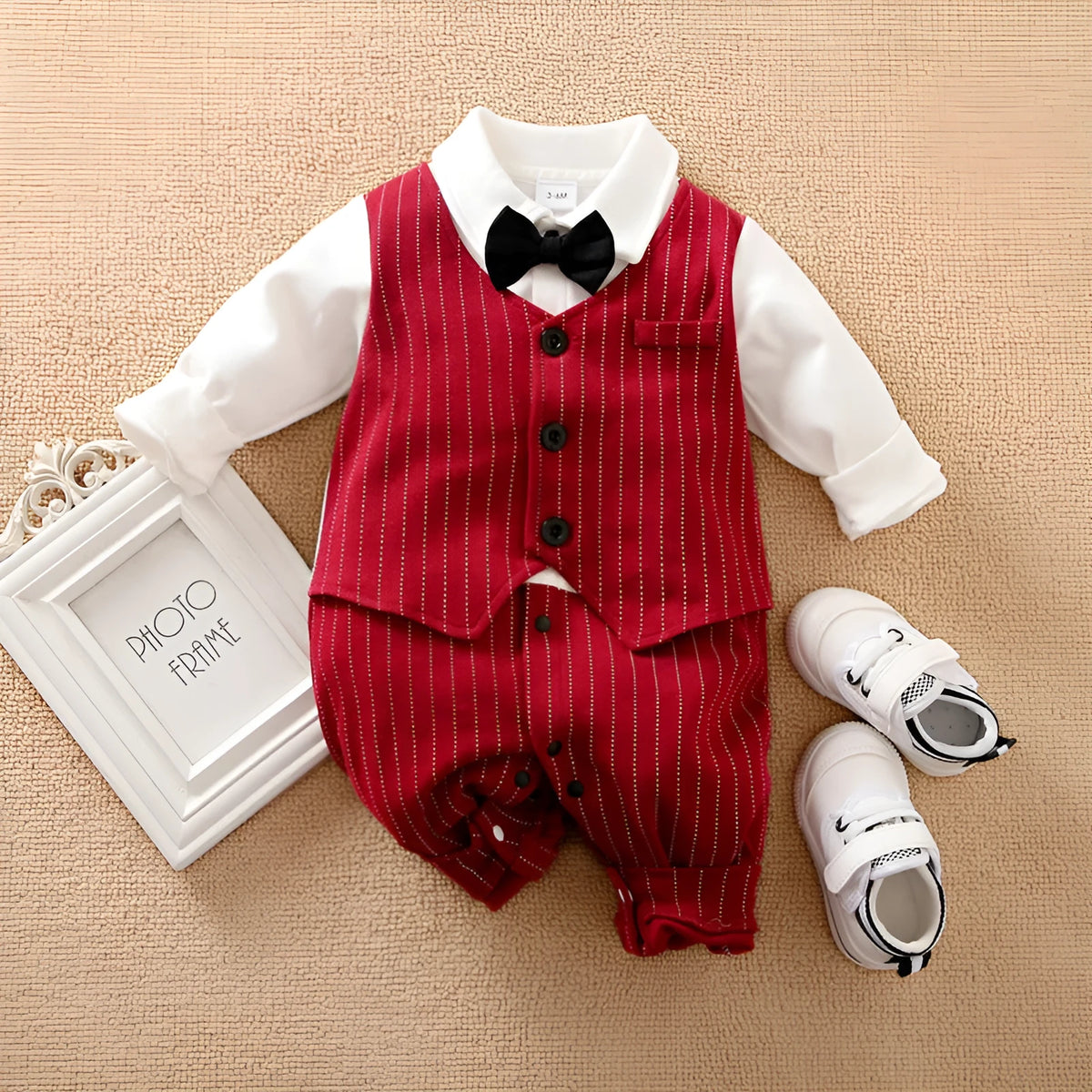 Wine red long sleeve cotton romper for a baby boy on a hanger.