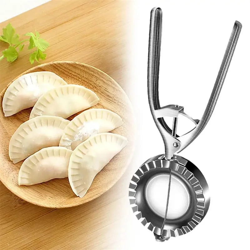 Silver stainless steel manual dumpling press with hinged handles on a wooden kitchen surface.