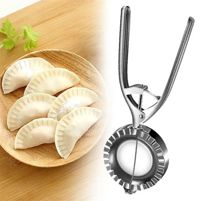 Silver stainless steel manual dumpling press tool on a wooden kitchen surface