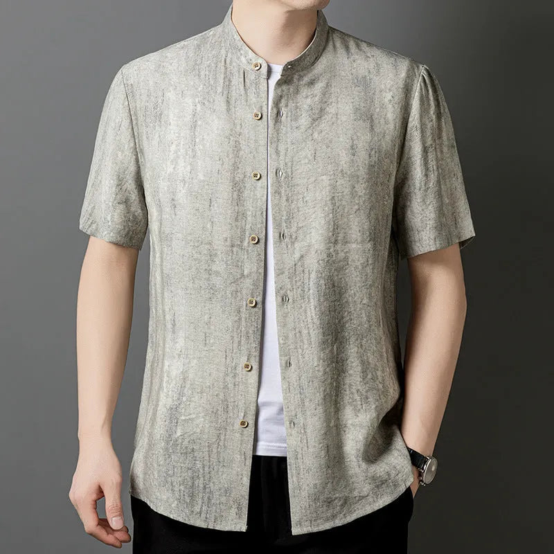 Man wearing a loose-fit grey linen blend short-sleeve shirt with a stand collar.