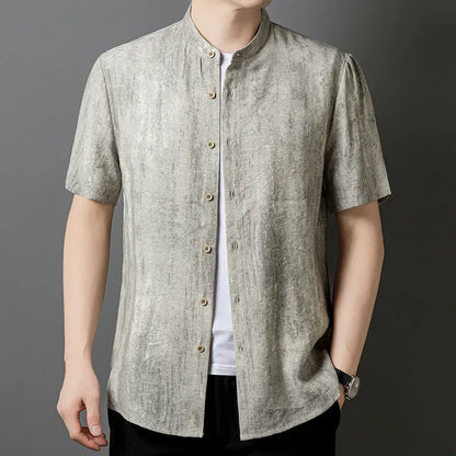 Man wearing a loose-fit grey linen blend short-sleeve shirt with a stand collar.