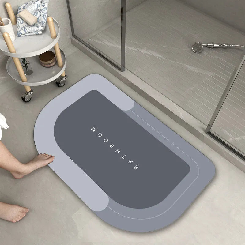 Oval diatomite bathroom floor mat in blue with natural rubber non-slip backing on tiled floor.