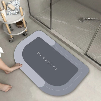 Oval diatomite bathroom floor mat in blue with natural rubber non-slip backing on tiled floor.