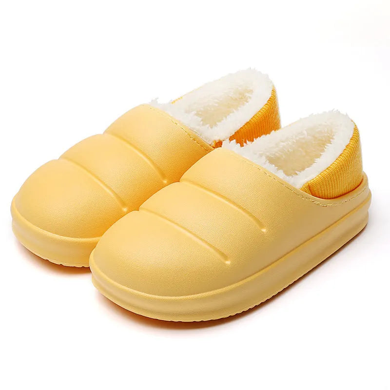 Pair of yellow waterproof EVA slippers with plush lining and a textured non-slip sole on a wooden floor.