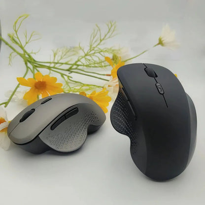 Grey and black wireless notebook mouse with USB charging cable on a laptop keyboard