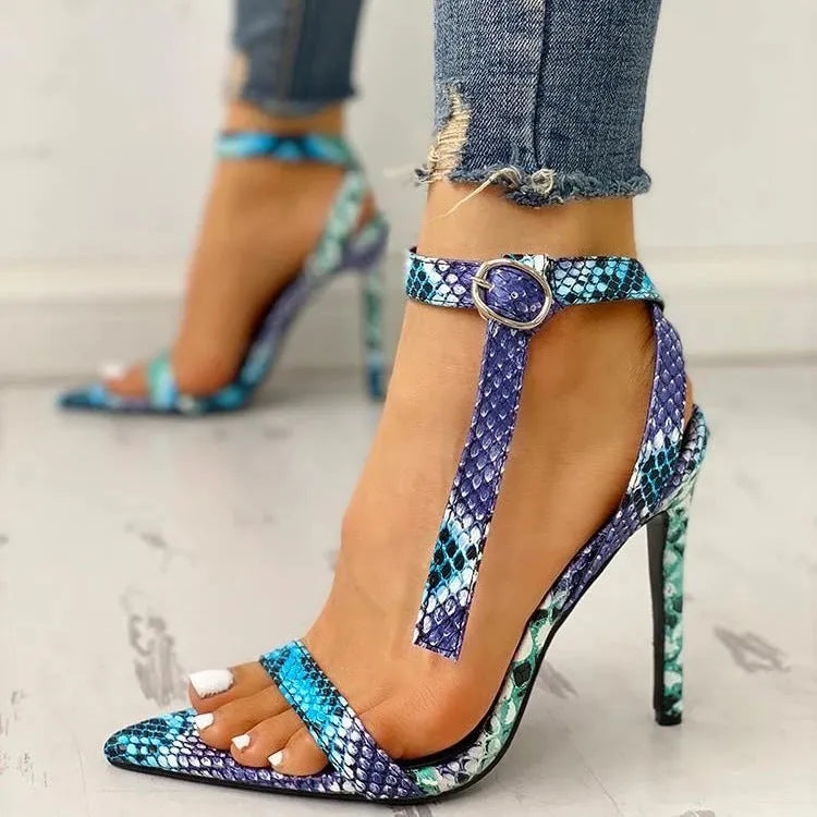 Blue women's buckle sandals with hollow-out detail and pointed toe on a white background.