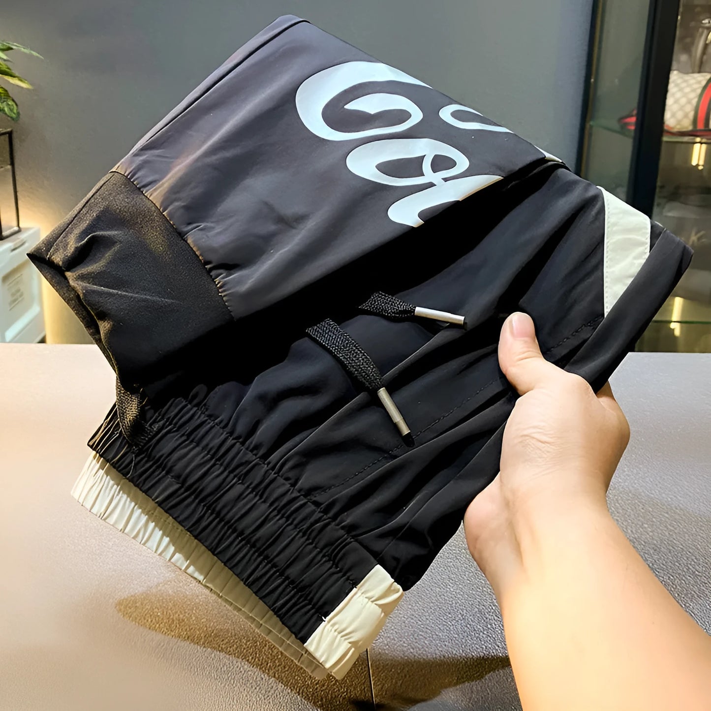 Black men's cropped casual trousers with ankle band made from thin ice silk cotton fabric.