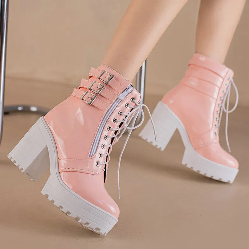 Women's black chunky heel ankle boots with round toe and front lace-up on a wooden floor.