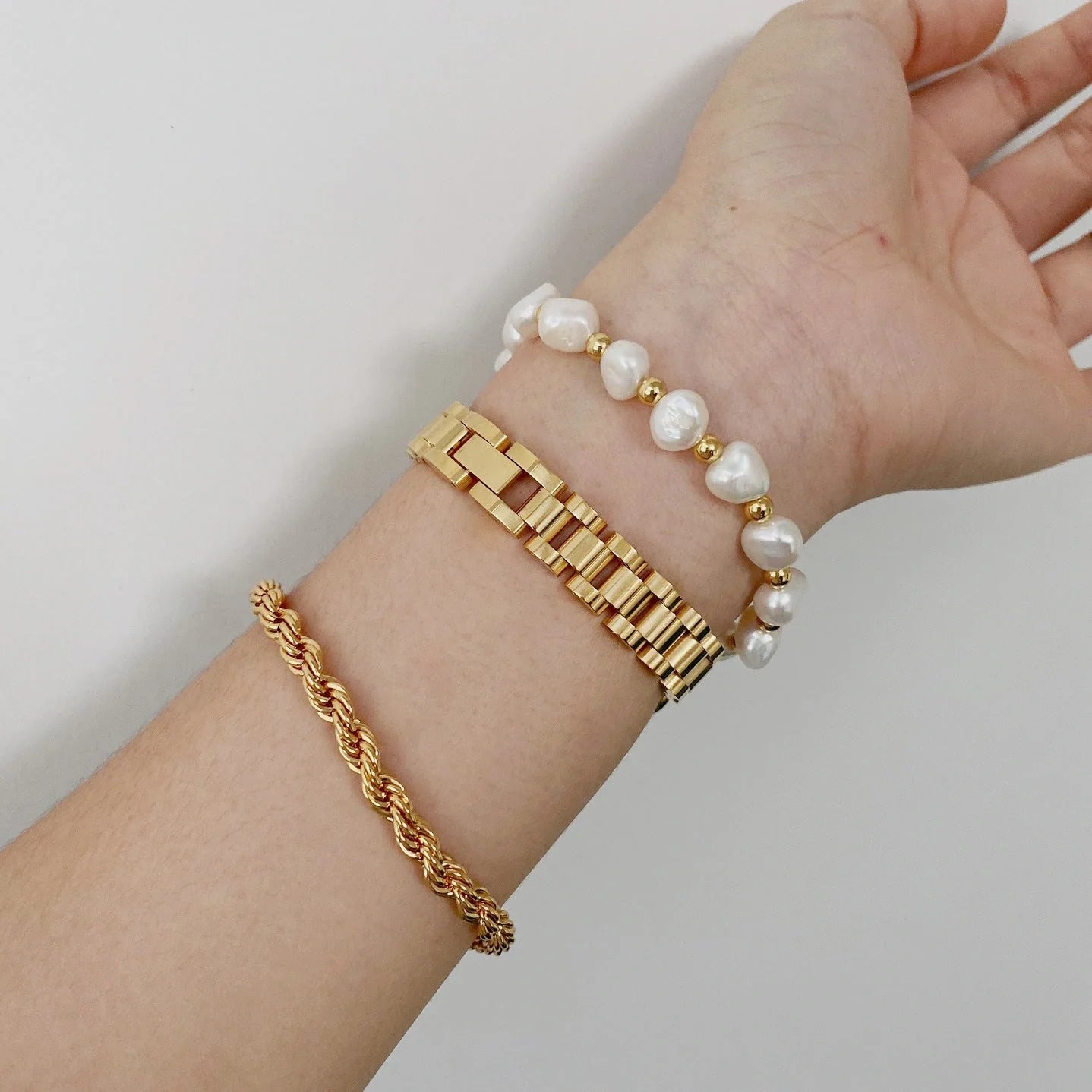 Elegant titanium steel bracelet watch with adjustable, geometric design in gold and stainless steel colours
