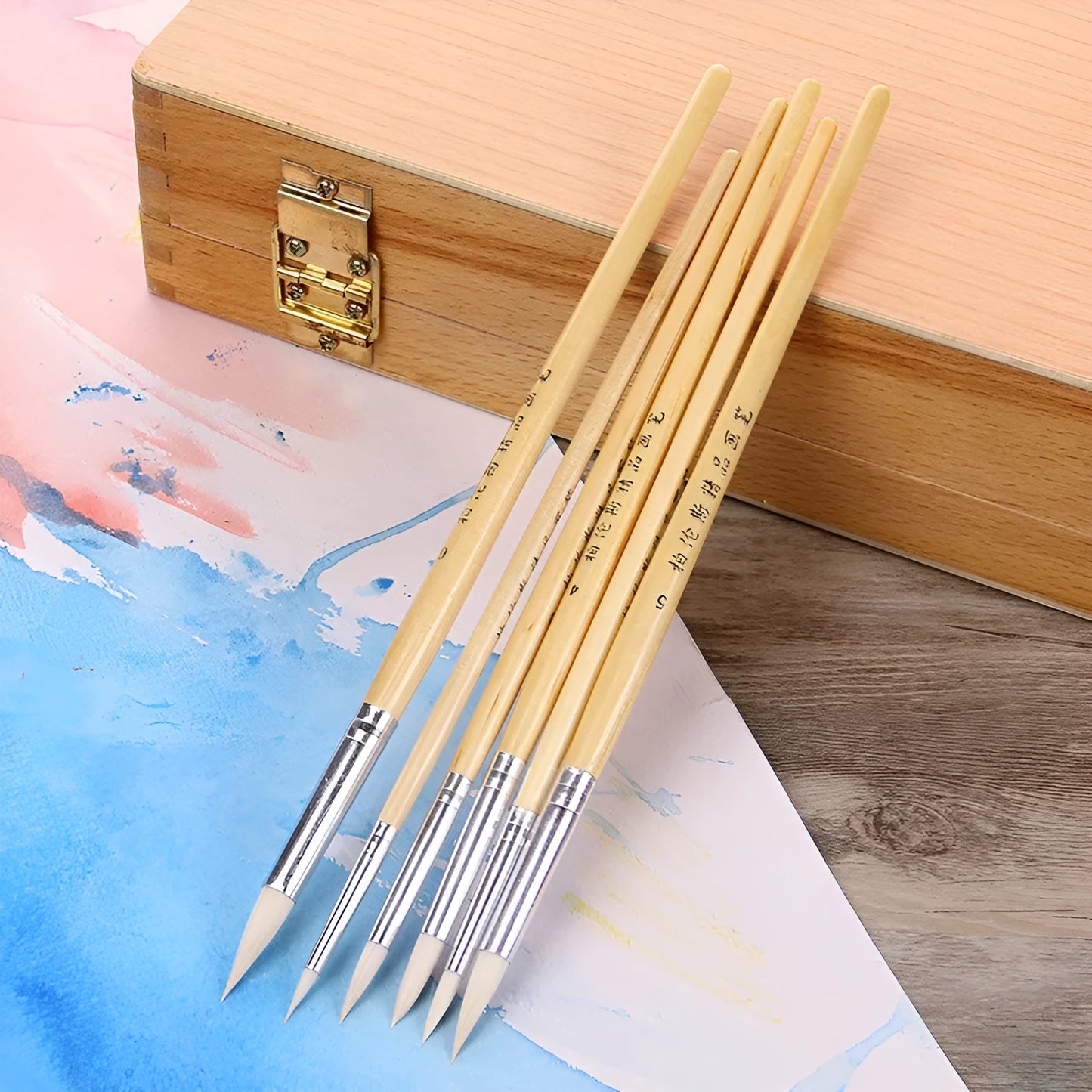 Six wooden-handled pen brushes with pointed wool bristles in conventional colours for artistic line work