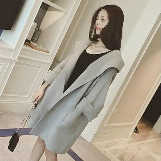 Plus size woman modelling a loose fit grey thin coat with lace detailing and long sleeves.