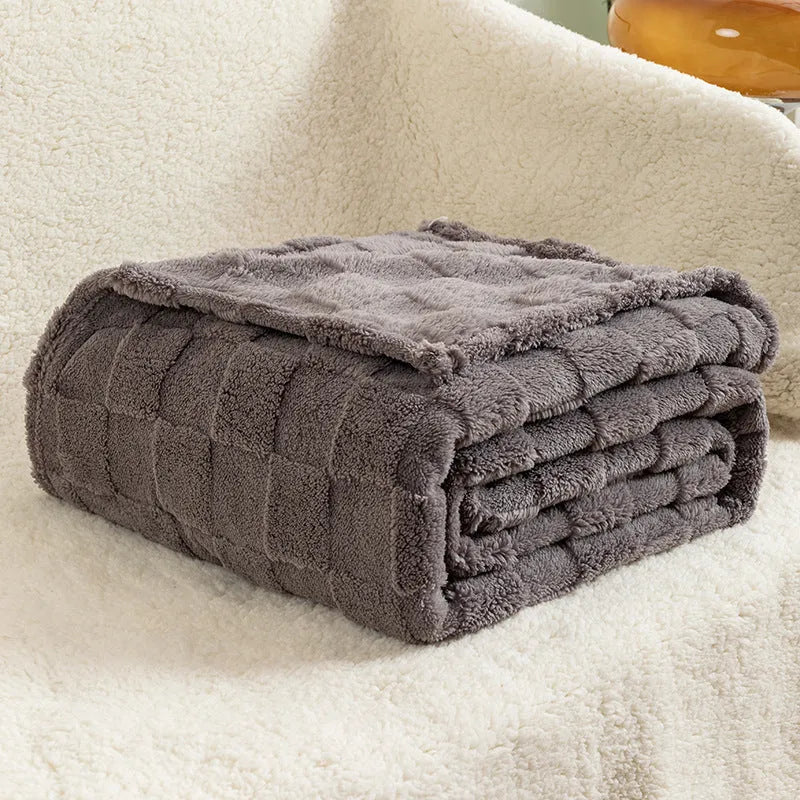 Geometric pattern polyester blanket in dark grey colour draped over sofa