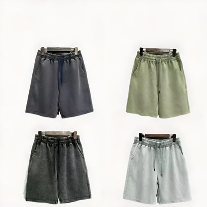 Man wearing loose-fit, straight-leg distressed cotton shorts in a solid colour