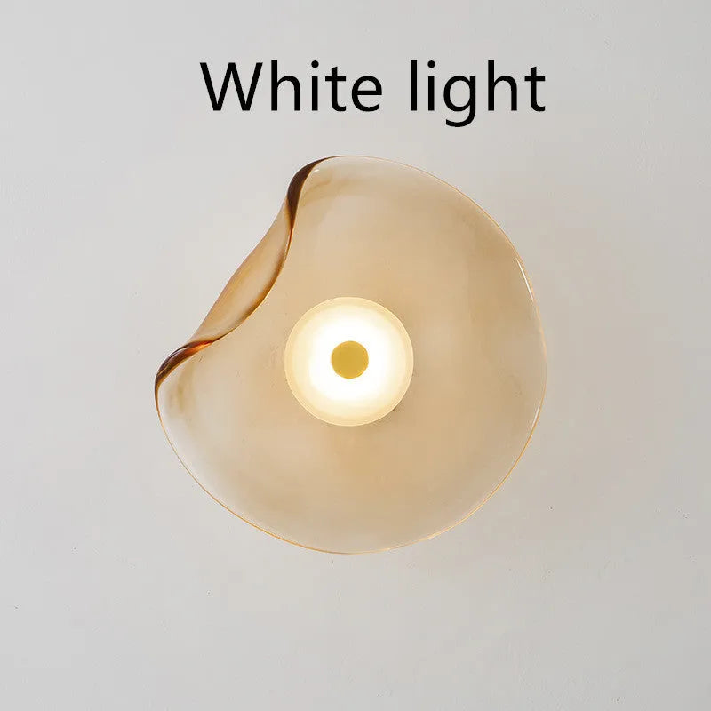 Round glass wall lamp mounted beside bed in cognac colour with 220V operation for bedside lighting
