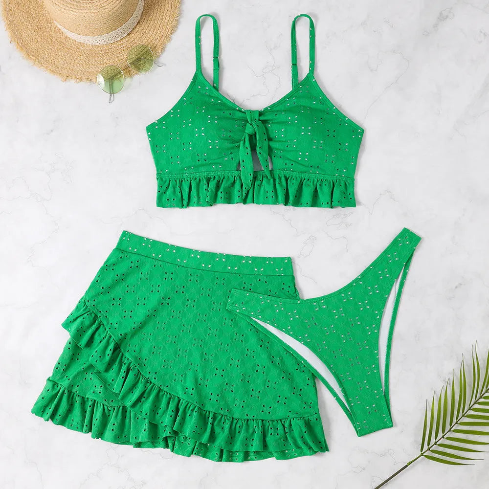 Women's solid colour three-piece bikini swimsuit with a split hip skirt.