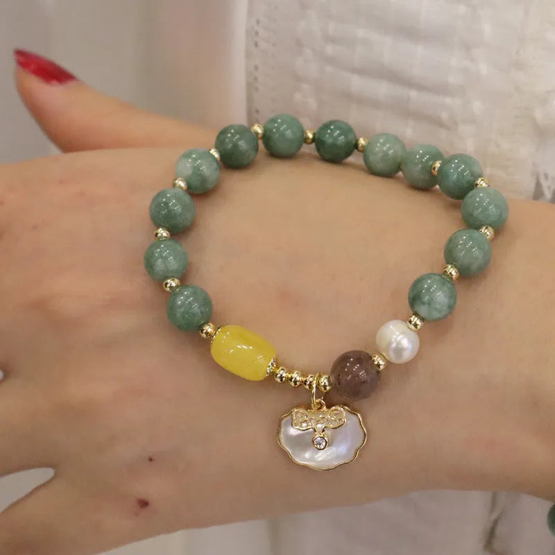 Light green jade bead bracelet with a shell charm and adjustable metal clasp.