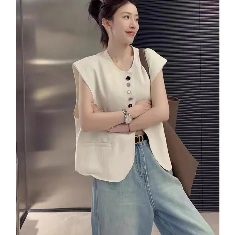 Women's loose-fit milky white polyester vest with pockets, shown on a model, demonstrating its short 40cm length.