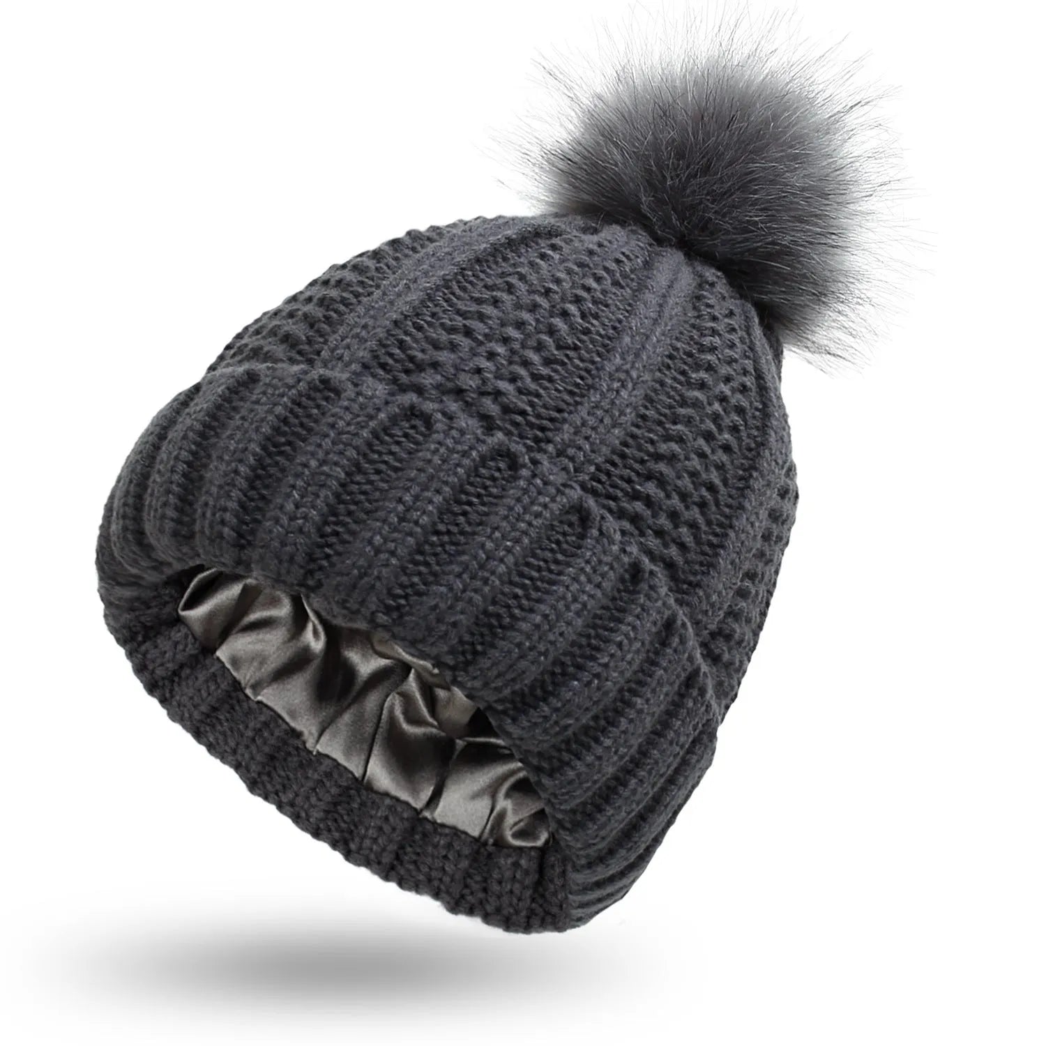 Woman wearing a wine red wool beanie hat with a faux fur pom pom and satin lining.
