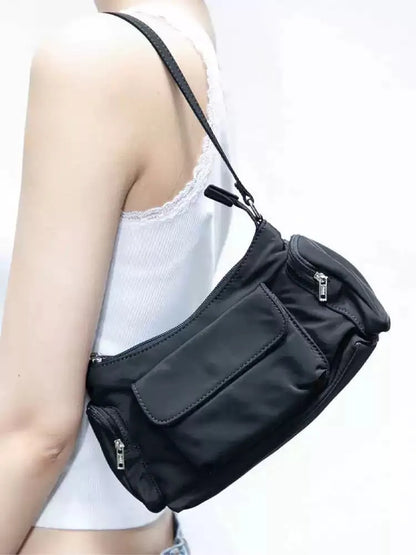 Black lightweight nylon shoulder bag with two pockets and side stitch detailing, dimensions 24cm x 9cm x 14cm.